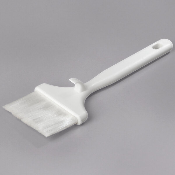 A white Carlisle Sparta Spectrum pastry brush with a white handle.