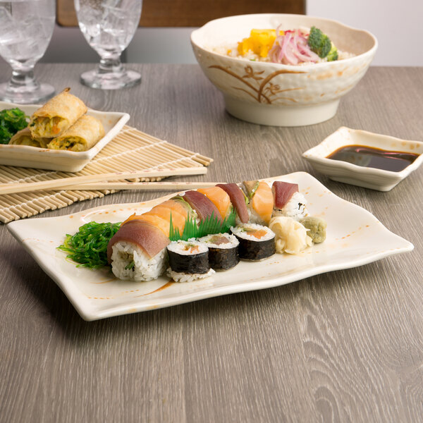 A rectangular Thunder Group melamine plate with sushi and vegetables on it.