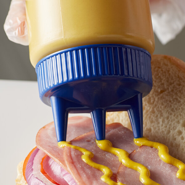 A Vollrath wide mouth squeeze bottle with mustard being poured onto a sandwich.