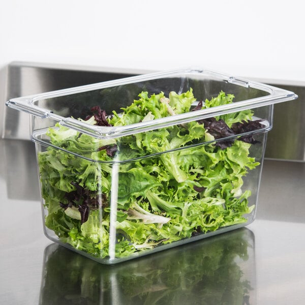 A Carlisle clear plastic food pan filled with lettuce.