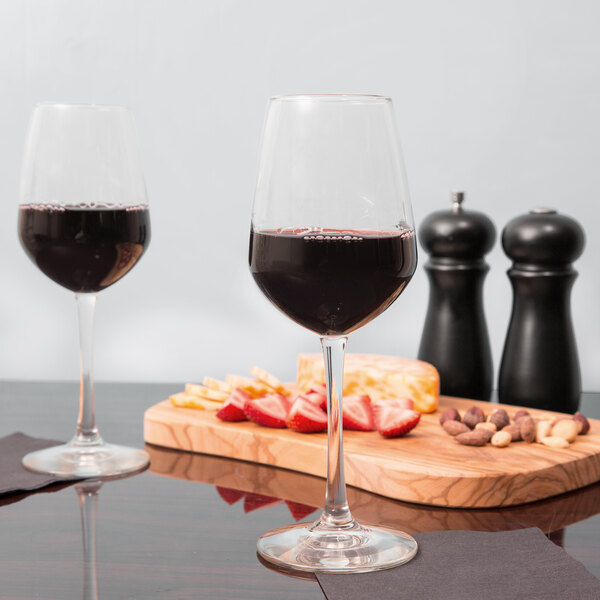 A close-up of two Libbey Vina wine glasses filled with wine on a table