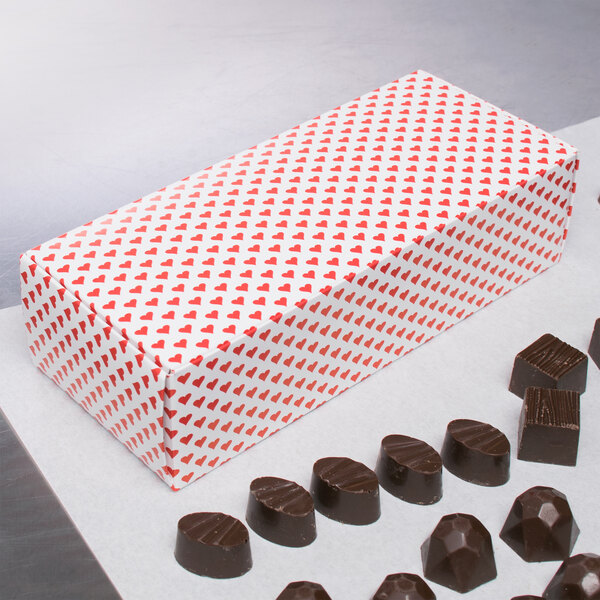 A 1-piece Valentine's Day heart candy box on a counter filled with chocolates.