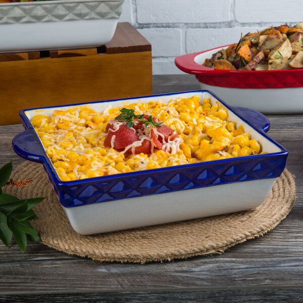 A Tuxton cobalt band square casserole dish filled with macaroni and cheese on a table.