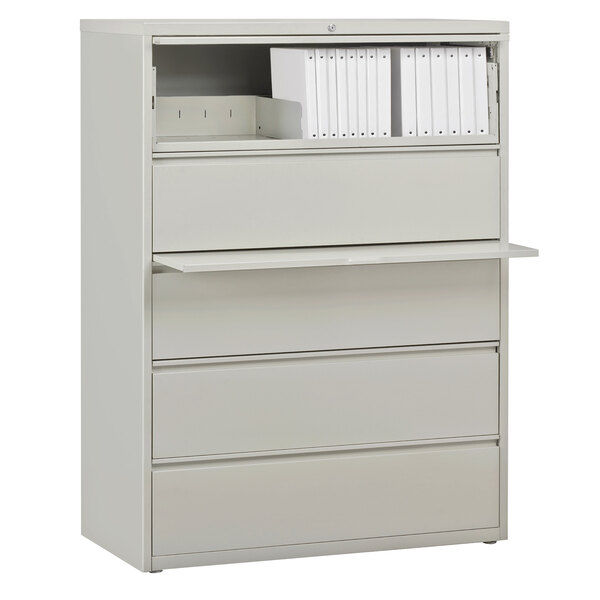 A gray Hirsh Industries lateral file cabinet with three drawers and roll out binder storage.