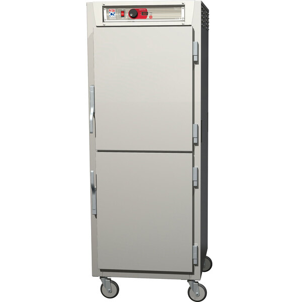 A white Metro C5 8 Series reach-in heated holding cabinet with two Dutch solid doors on wheels.