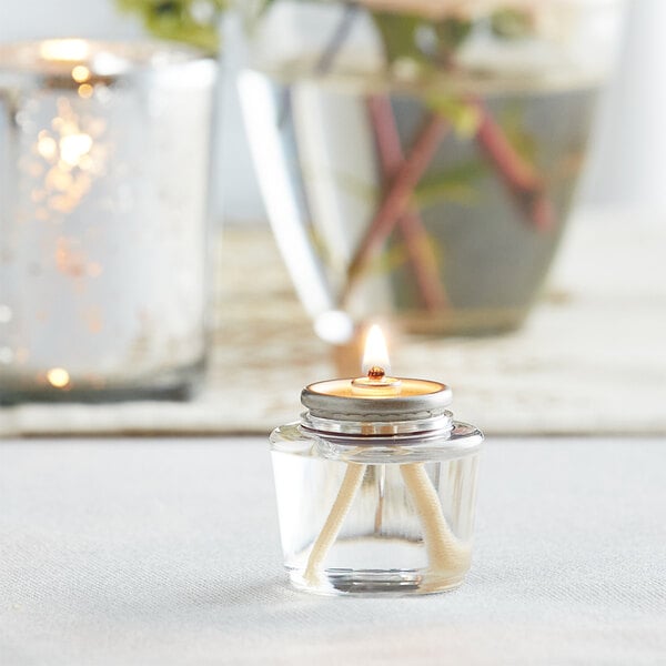 A Leola liquid paraffin candle in a glass container on a table.