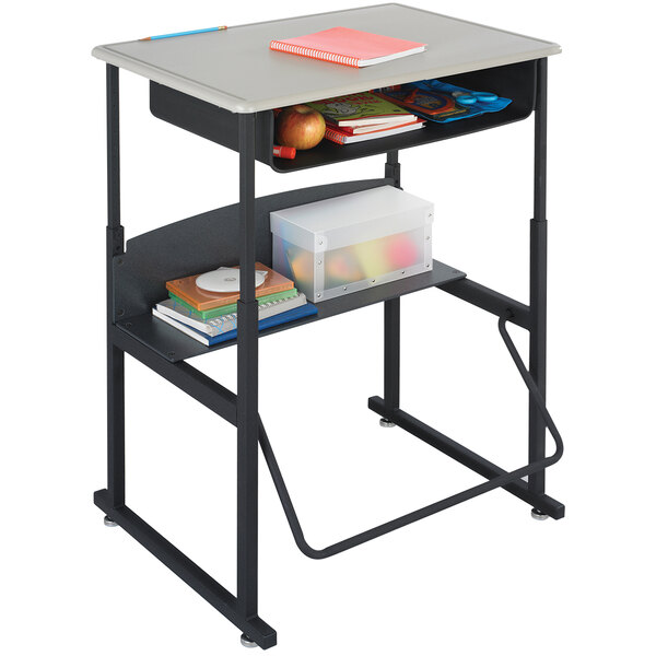 A black Safco steel stand-up desk with a beige top and book box.