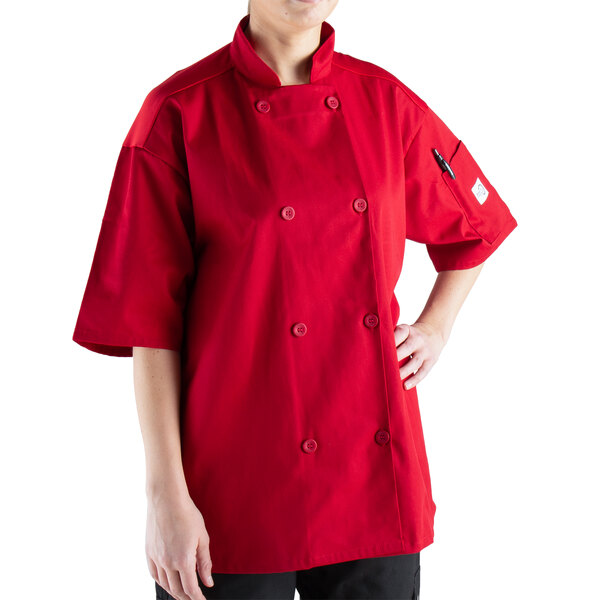 A woman wearing a red Mercer Culinary Millennia Air chef coat with full mesh back.