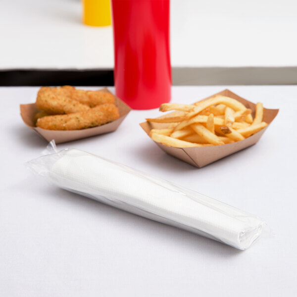 White table with a tray of fries and a red and yellow bottle on a white surface with a blue and red bag.