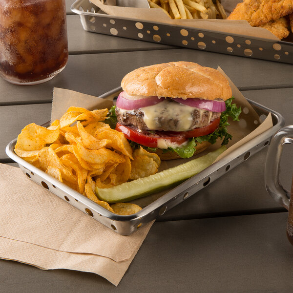 A Tablecraft stainless steel serving tray with a cheeseburger, chips, and a glass of ice.