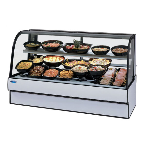 A Federal Industries curved glass refrigerated deli case filled with different types of food.