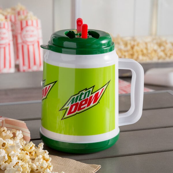 A green and white Mountain Dew Mini Tanker with a red straw next to popcorn.