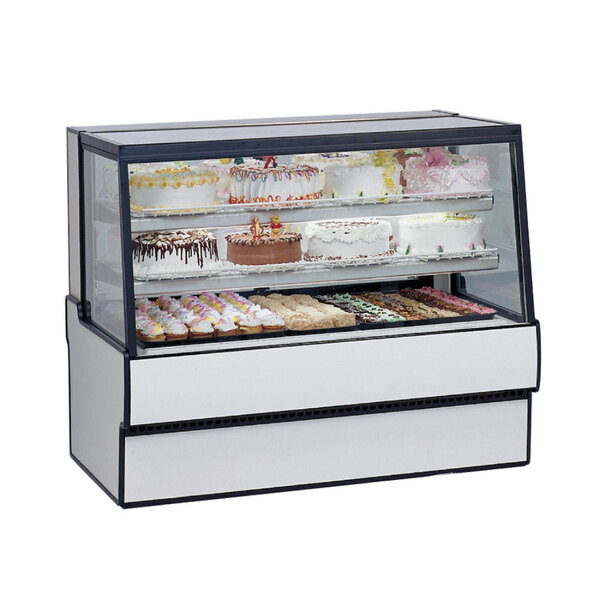 A Federal Industries low full service dry bakery display case with cakes and cupcakes inside.