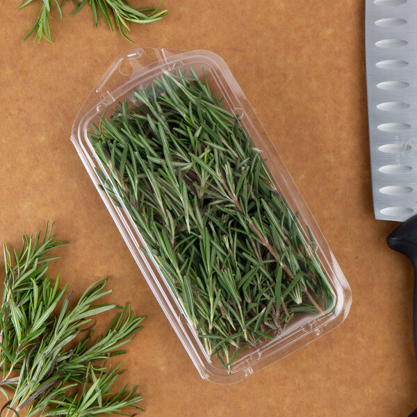 A clear plastic clamshell with rosemary sprigs inside.