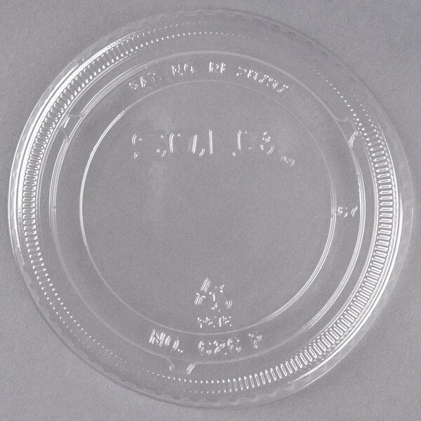 A clear Solo flat plastic lid with writing on it.