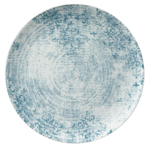 A close-up of a blue Schonwald porcelain coupe plate with white ornaments.