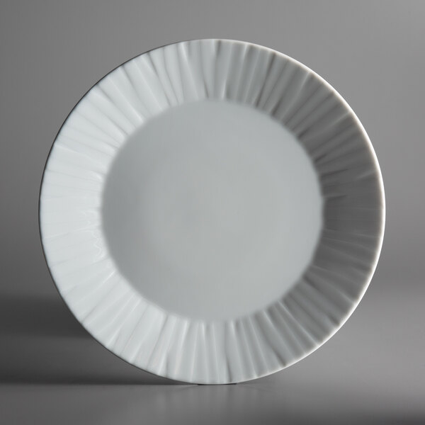 A close-up of a Schonwald white porcelain plate with a wavy edge.
