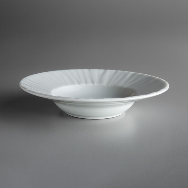 A close up of a Schonwald white porcelain bowl with a rippled edge.