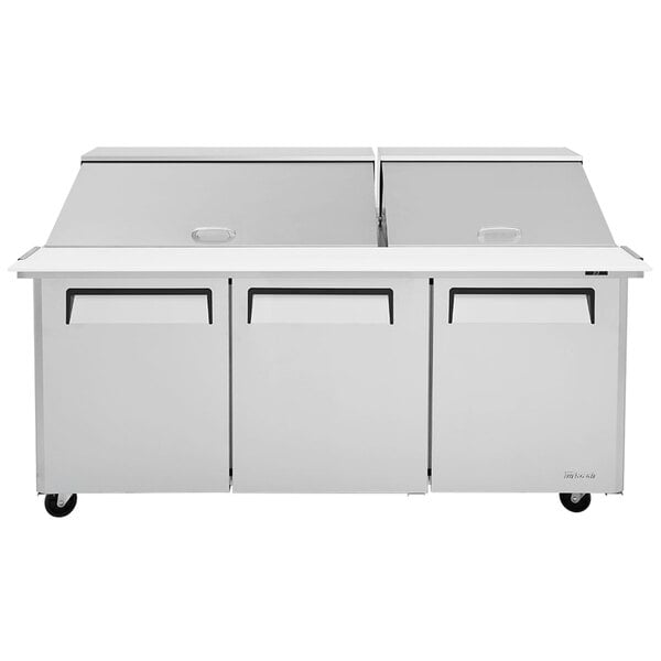 A Turbo Air stainless steel refrigerated sandwich prep table with three doors.