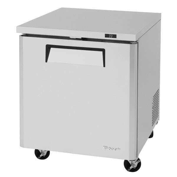 A white Turbo Air undercounter refrigerator with black wheels.