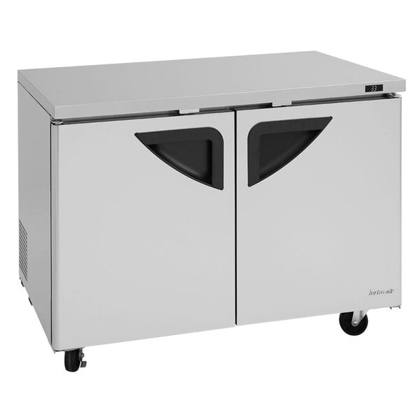 A Turbo Air stainless steel undercounter refrigerator with two black doors.