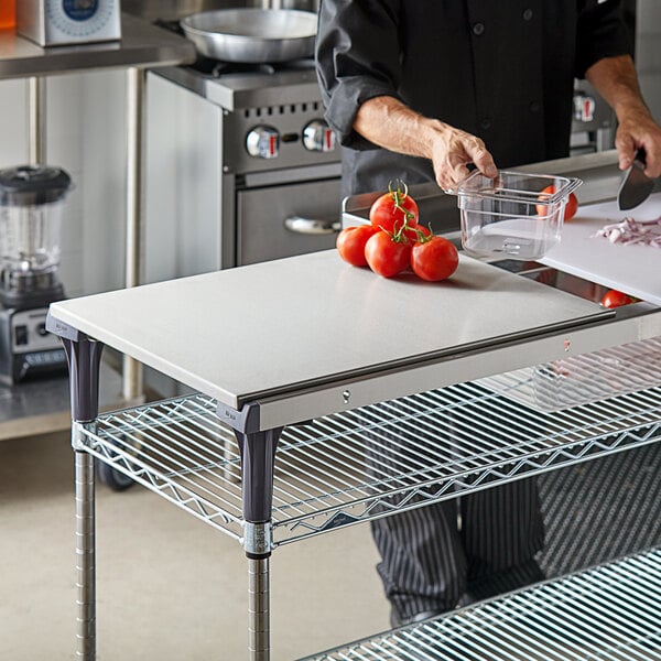 A chef cutting tomatoes on a Metro stainless steel work surface.