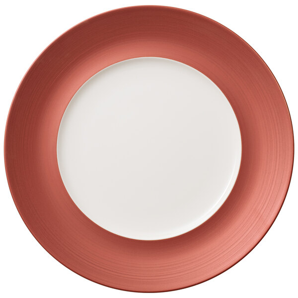 A white porcelain plate with a red copper rim.