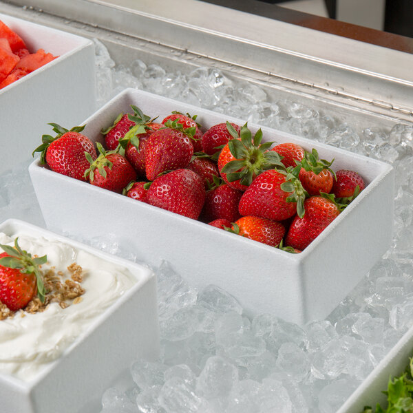 A white G.E.T. Enterprises Bugambilia rectangular salad bowl of strawberries on ice.