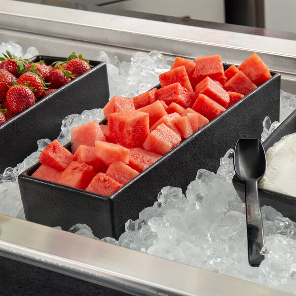 A G.E.T. Enterprises black rectangular salad bowl filled with watermelon cubes on a tray.