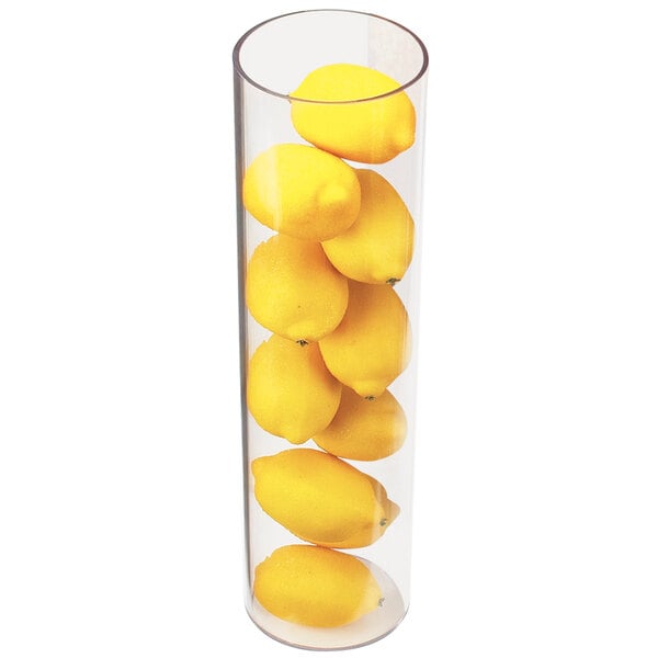A clear round acrylic vase with yellow lemons inside.