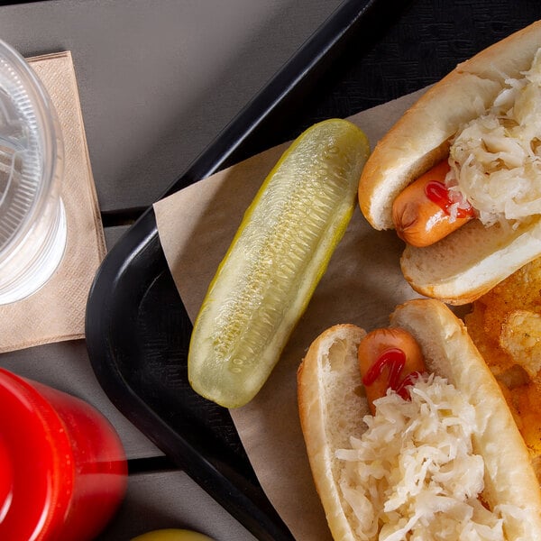 A tray of hot dogs with sauerkraut and Nathan's Famous pickle halves.