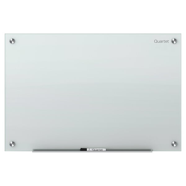 A Quartet frameless white glass dry-erase board on a counter with a marker.