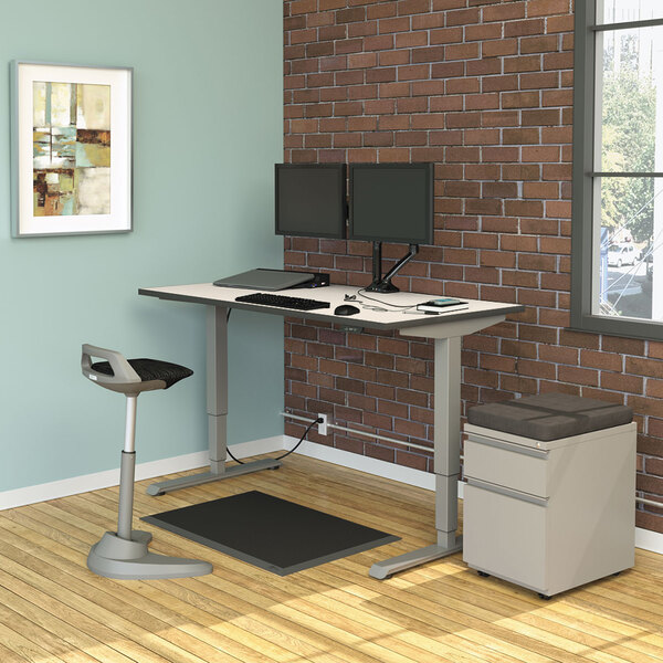 A white and gray rectangular table top on a wood table with a computer and a stool.