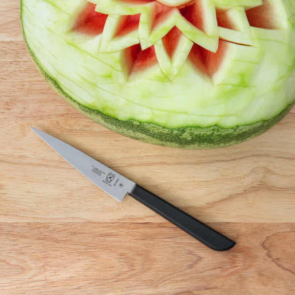 A watermelon carved into a star shape with a Mercer Culinary Japanese style carving knife.