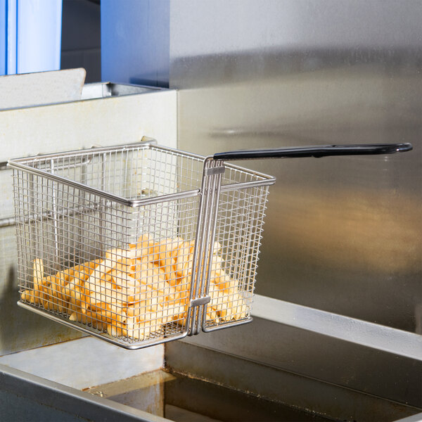 A Cecilware fryer basket full of french fries on a counter.