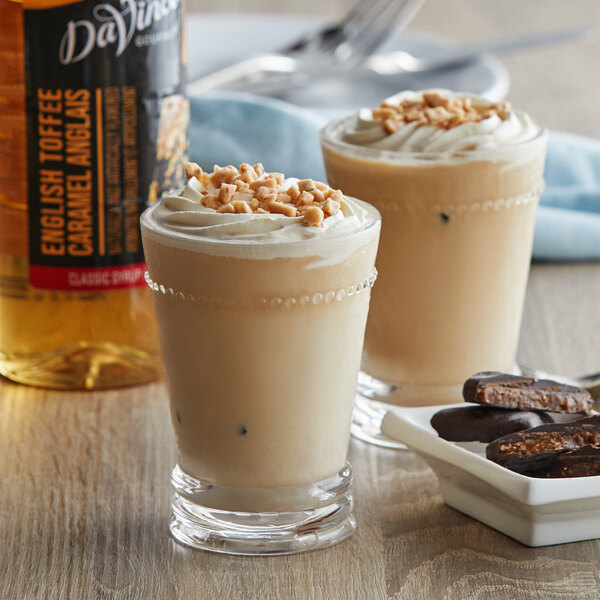 Two glasses of milkshakes with whipped cream and cookies made with DaVinci Gourmet Classic English Toffee Flavoring Syrup.