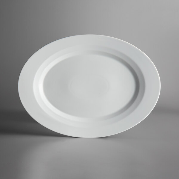 A Schonwald bone white porcelain platter with a raised rim on a gray surface.