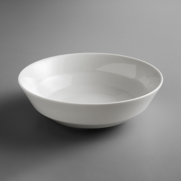 A Schonwald bone white porcelain salad bowl on a gray surface.