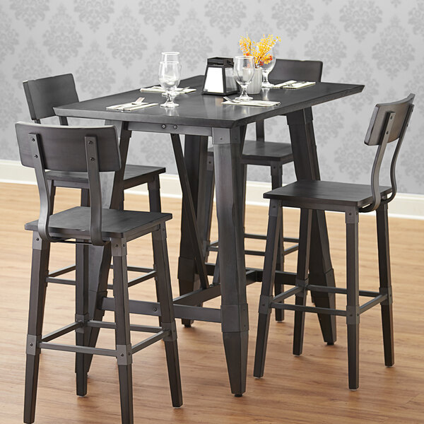 A table with chairs and glasses on a Lancaster Table and Seating live edge table top.
