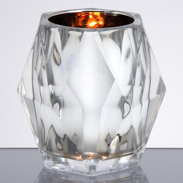 A Sterno Classic Elegance glass candle holder with a lit candle inside.