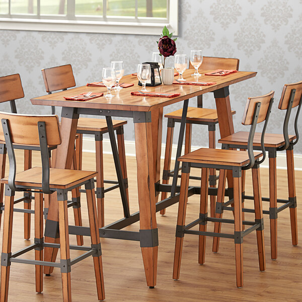 A Lancaster Table & Seating live edge wood table with chairs and wine glasses.