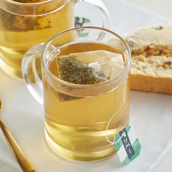 A glass mug of Numi Organic Mate Lemon tea with a tea bag in it.