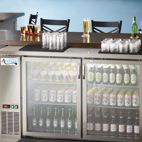 An Avantco back bar refrigerator with bottles and glasses inside.