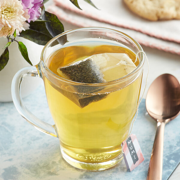 A glass of Numi Organic Jasmine Green Tea with a tea bag in it.