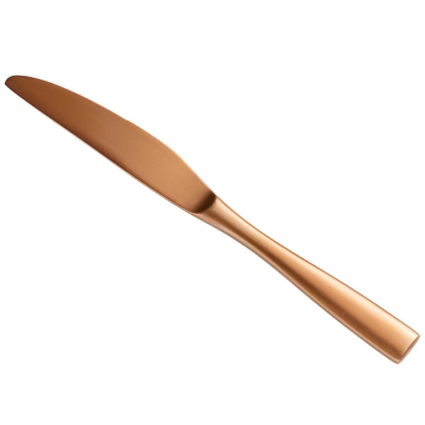 A close up of a Bon Chef matte rose gold stainless steel dinner knife with a copper color.