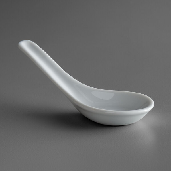 A white porcelain soup spoon with a white handle.