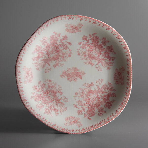A white porcelain plate with a pink and floral design.