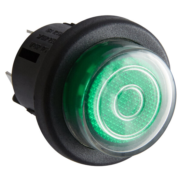 A black round device with a green push button light.