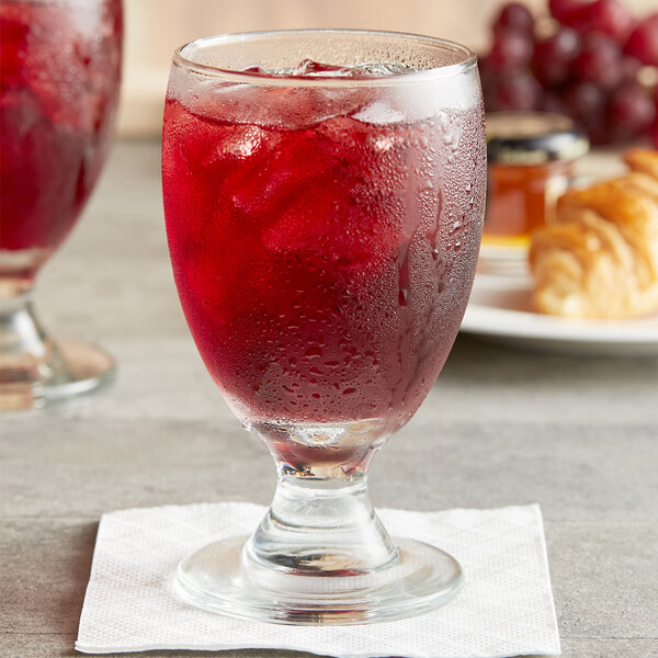 A glass with Ruby Kist grape juice and ice.