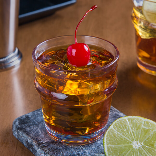 A Libbey Tritan plastic rocks glass with ice and a cherry on top.